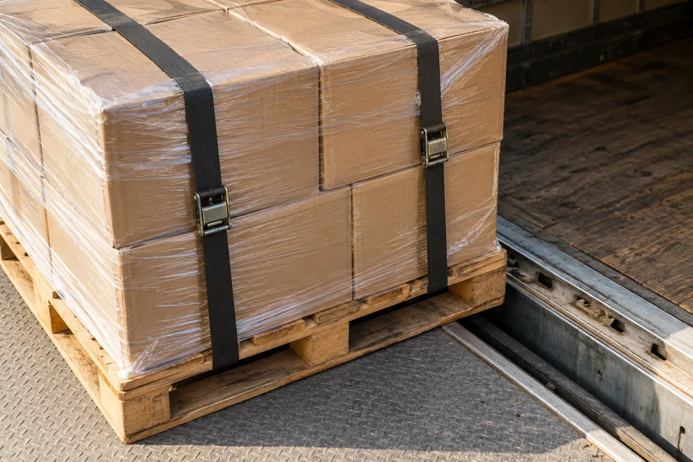 AI-generated concept photograph showing packaged cargo and freight-handling equipment at a loading area.